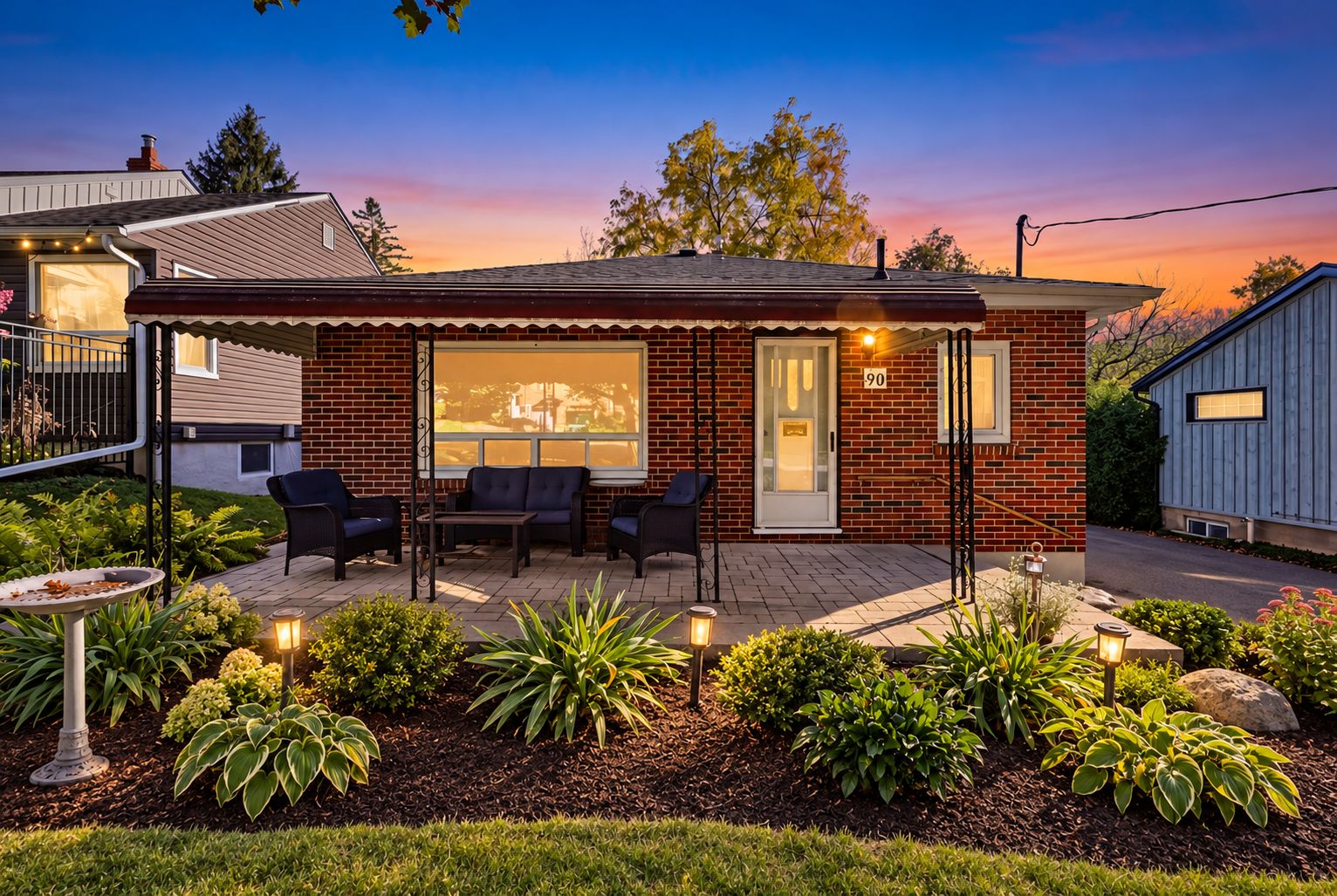 Twilight Brick Home with Glowing Garden Lights